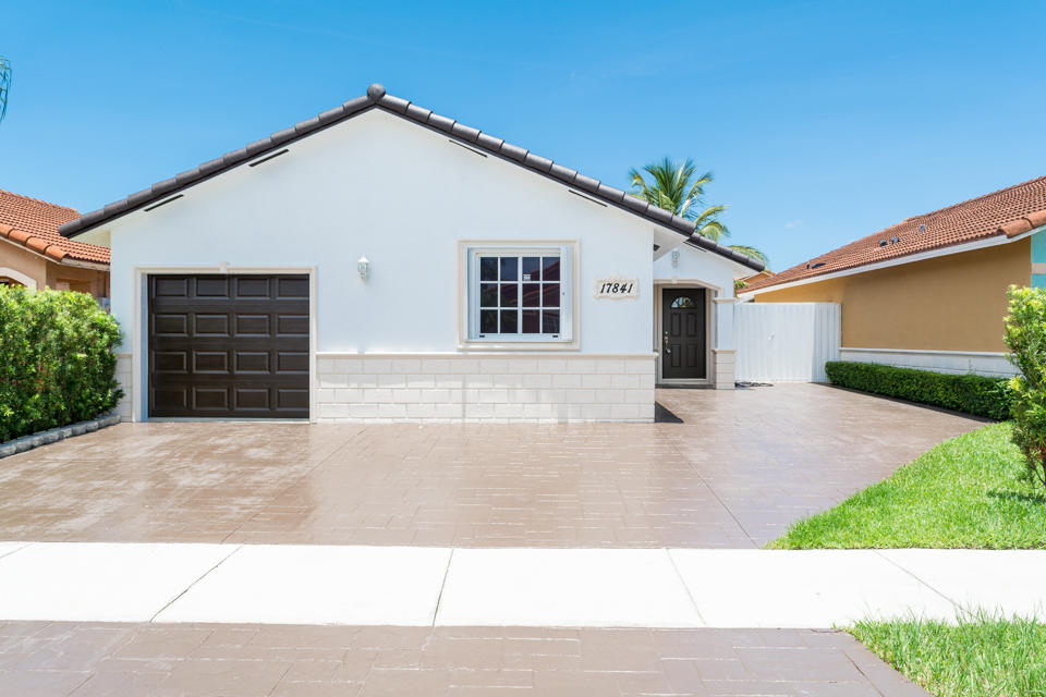 17841 Southwest 144th Avenue Miami, FL 33177 - Photo 3 of 19 a view of a house with a yard and garage