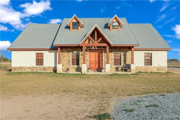a front view of a house with a garden and deck