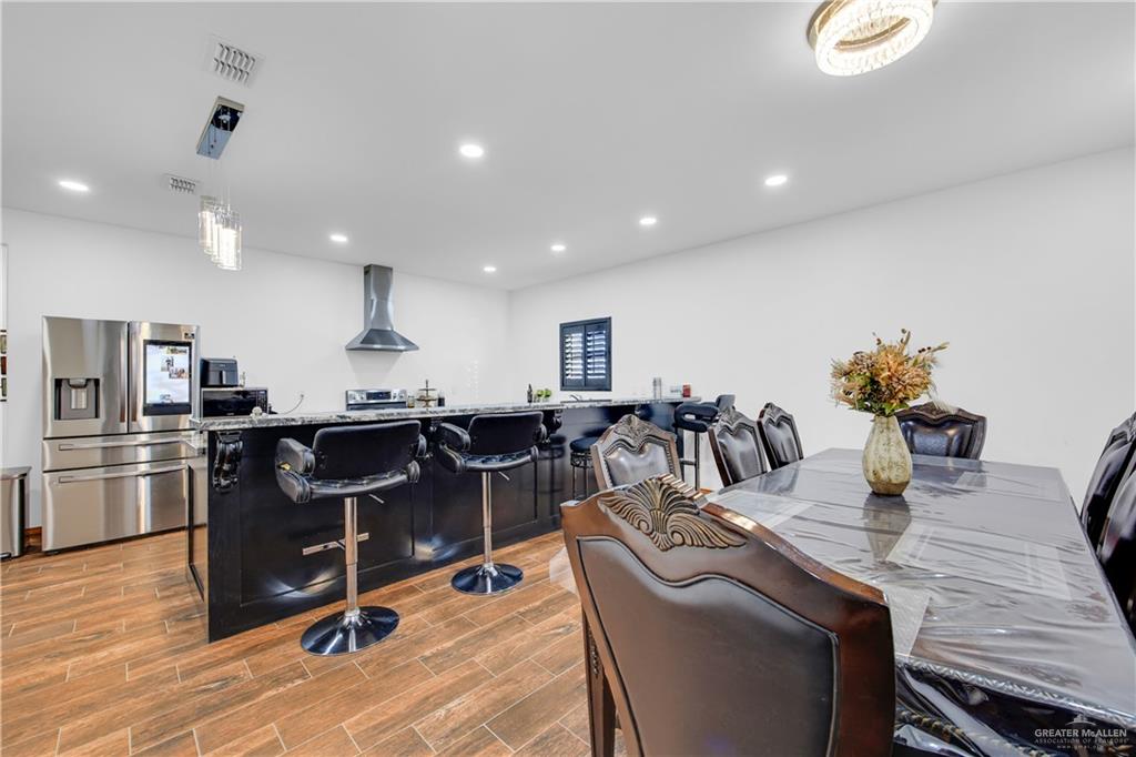 26072 Brushline Road Edcouch, TX 78538 - Photo 13 of 32 a living room with stainless steel appliances kitchen island granite countertop a table chairs and a refrigerator