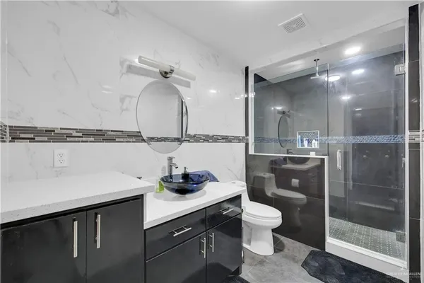 a bathroom with a sink a toilet and shower