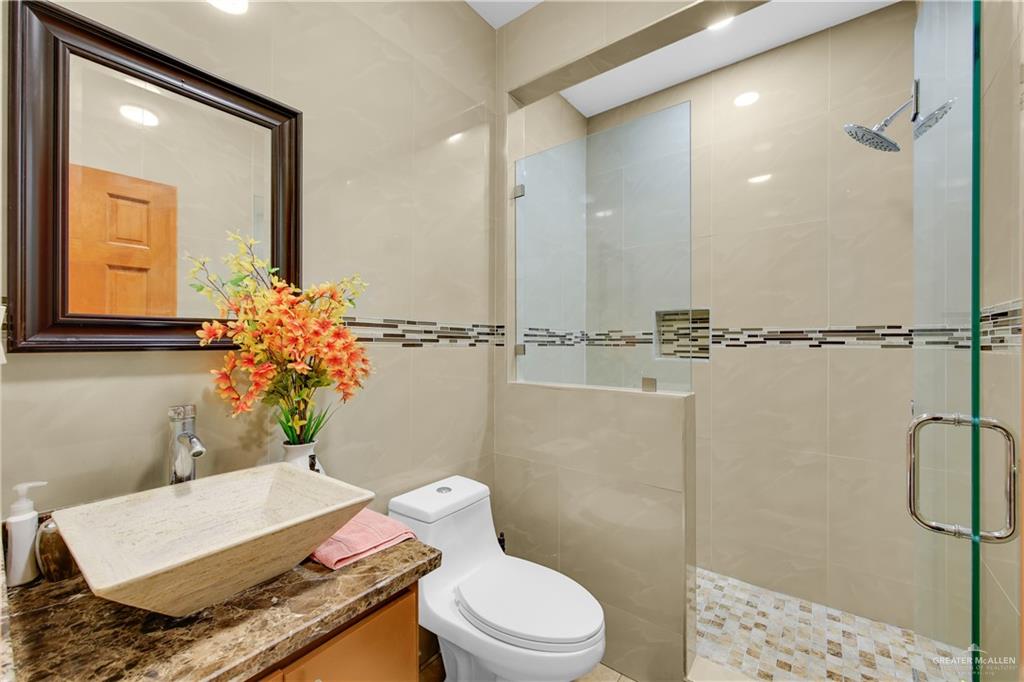 26072 Brushline Road Edcouch, TX 78538 - Photo 6 of 32 a bathroom with a granite countertop sink mirror vanity and toilet