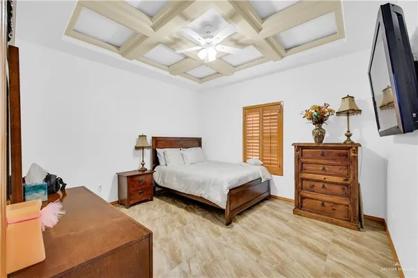 a bedroom with a bed and a flat tv screen on dresser