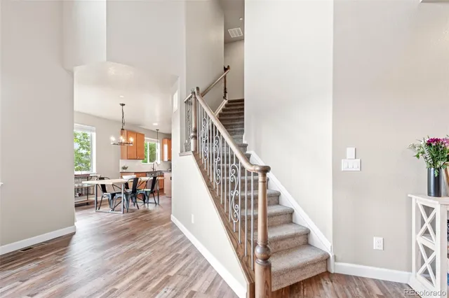 a kitchen with stainless steel appliances granite countertop sink stove and white cabinets with wooden floor