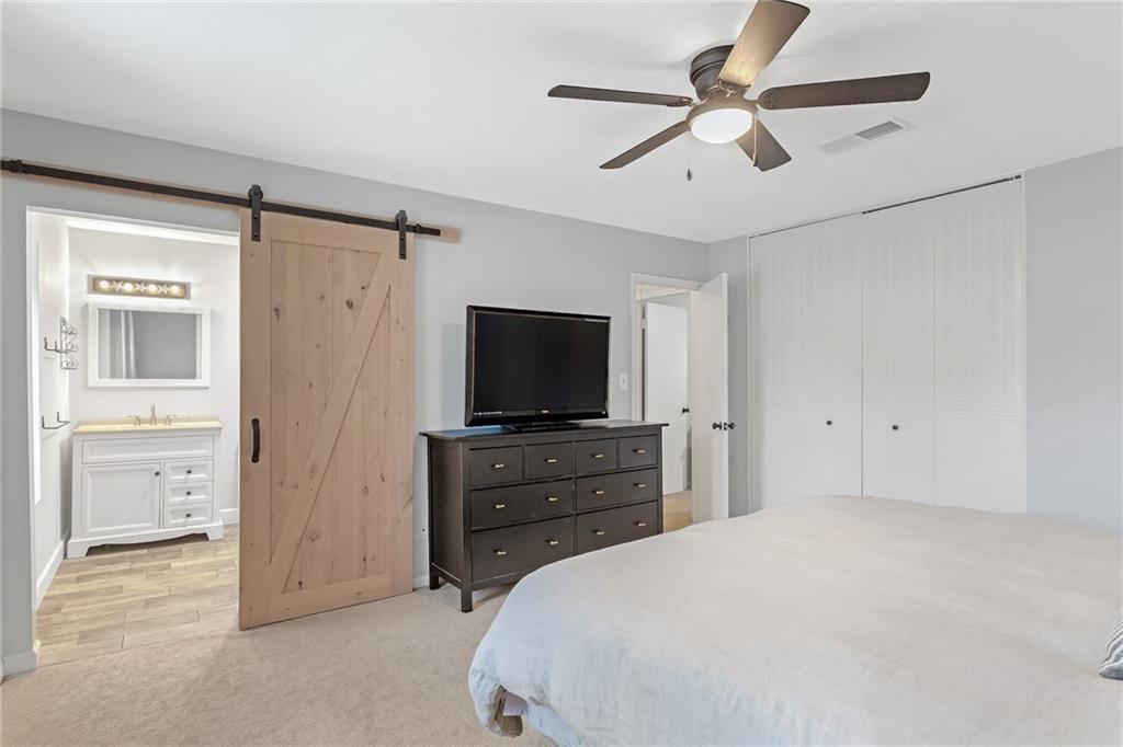 12 Surry County Place Northwest Atlanta, GA 30318 - Photo 14 of 27 a bedroom with a bed and a flat tv screen on dresser
