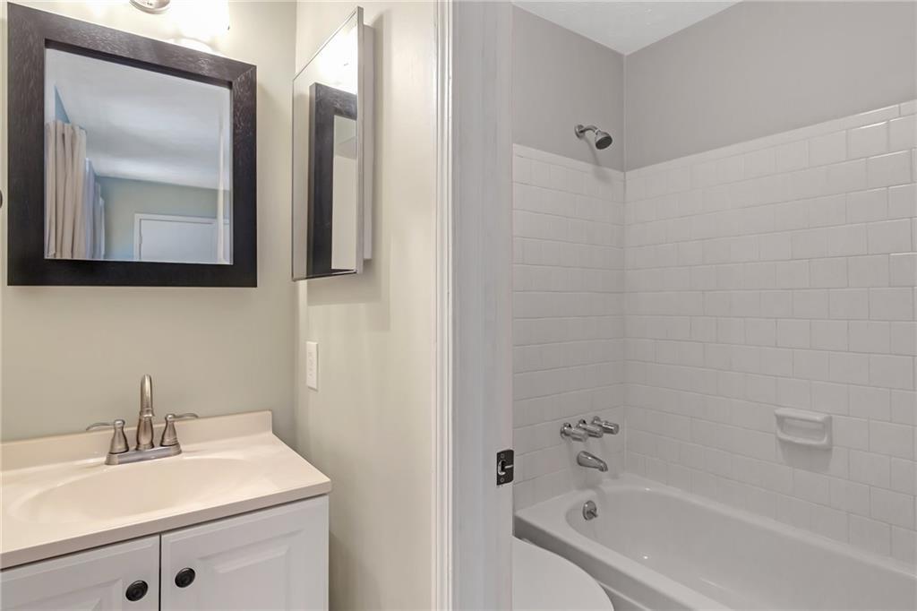 12 Surry County Place Northwest Atlanta, GA 30318 - Photo 20 of 27 a bathroom with a bathtub sink vanity and mirror