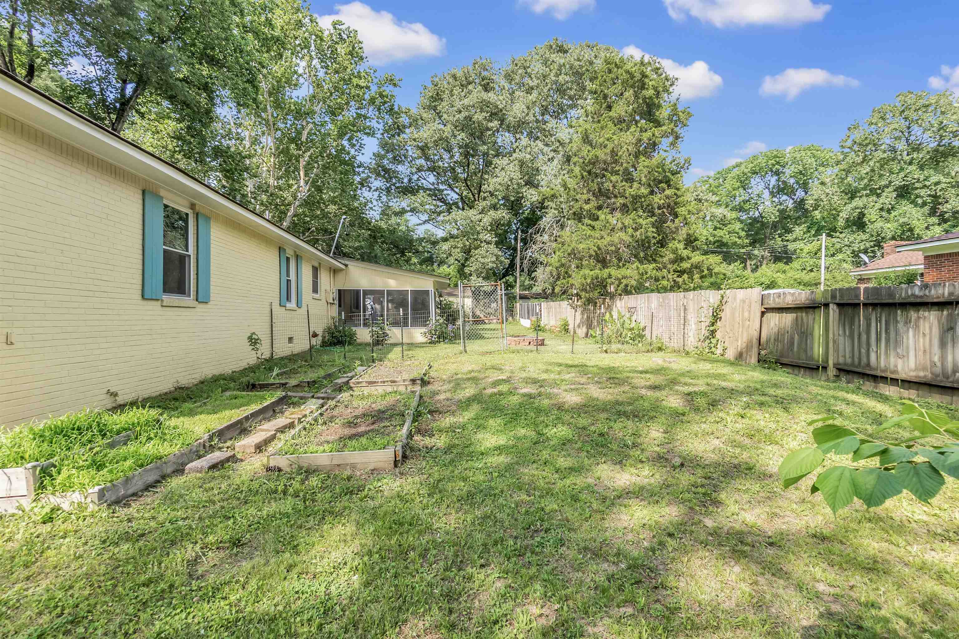 3024 Keats Road Bartlett, TN 38134 - Photo 28 of 32 Fenced backyard with a vegetable garden and a sunroom