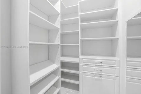 a view of walk in closet with empty racks