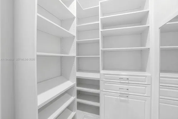 a view of walk in closet with empty racks