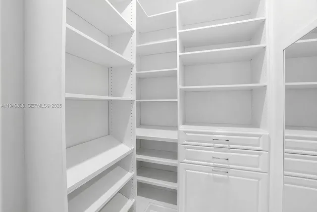 a view of walk in closet with empty racks