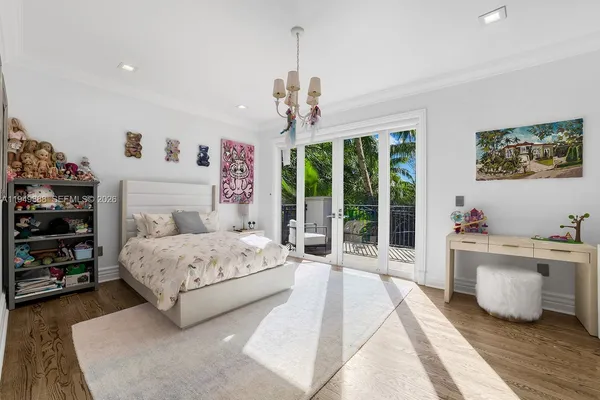 a spacious bedroom with a large bed and a chandelier