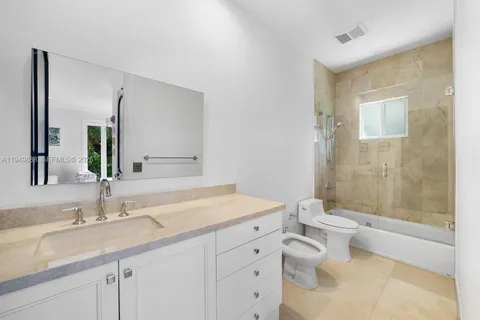 a bathroom with a granite countertop sink a toilet and shower