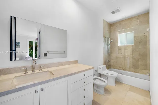 a bathroom with a granite countertop sink a toilet and shower
