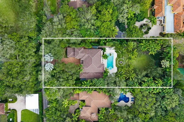 an aerial view of residential house with outdoor space and trees all around
