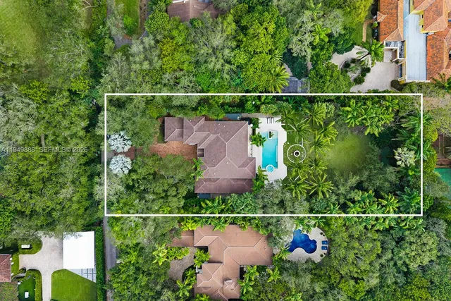 an aerial view of residential house with outdoor space and trees all around