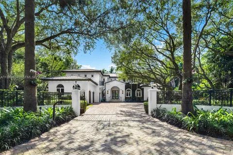 a white house that has tree in front of it