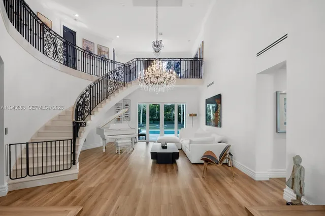 a living room with furniture floor to ceiling window and wooden floor