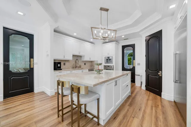 a large kitchen with stainless steel appliances a breakfast area