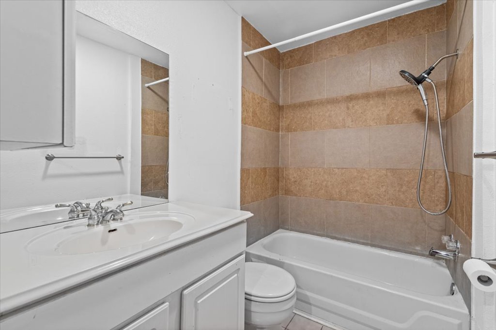 555 Harmon Hills Road, Unit A Dripping Springs, TX 78620 - Photo 5 of 29 Functional full bathroom featuring a tub-shower combination with tiled walls and a white vanity.