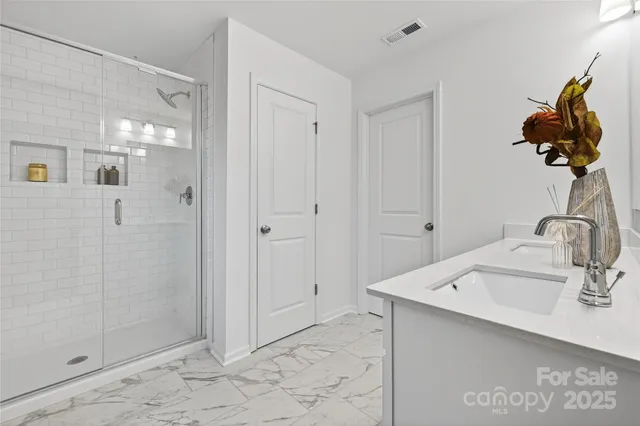 a bathroom with a sink mirror and shower