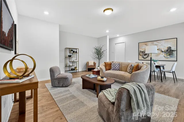a living room with furniture a rug and a floor to ceiling window