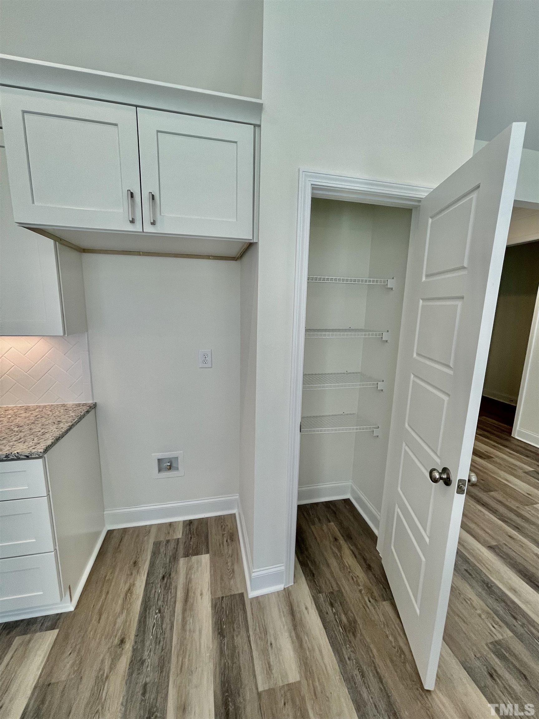 10623 West Old Spring Hope Road Spring Hope, NC 27882 - Photo 15 of 33 a view of walk in closet with wooden floor and staircase