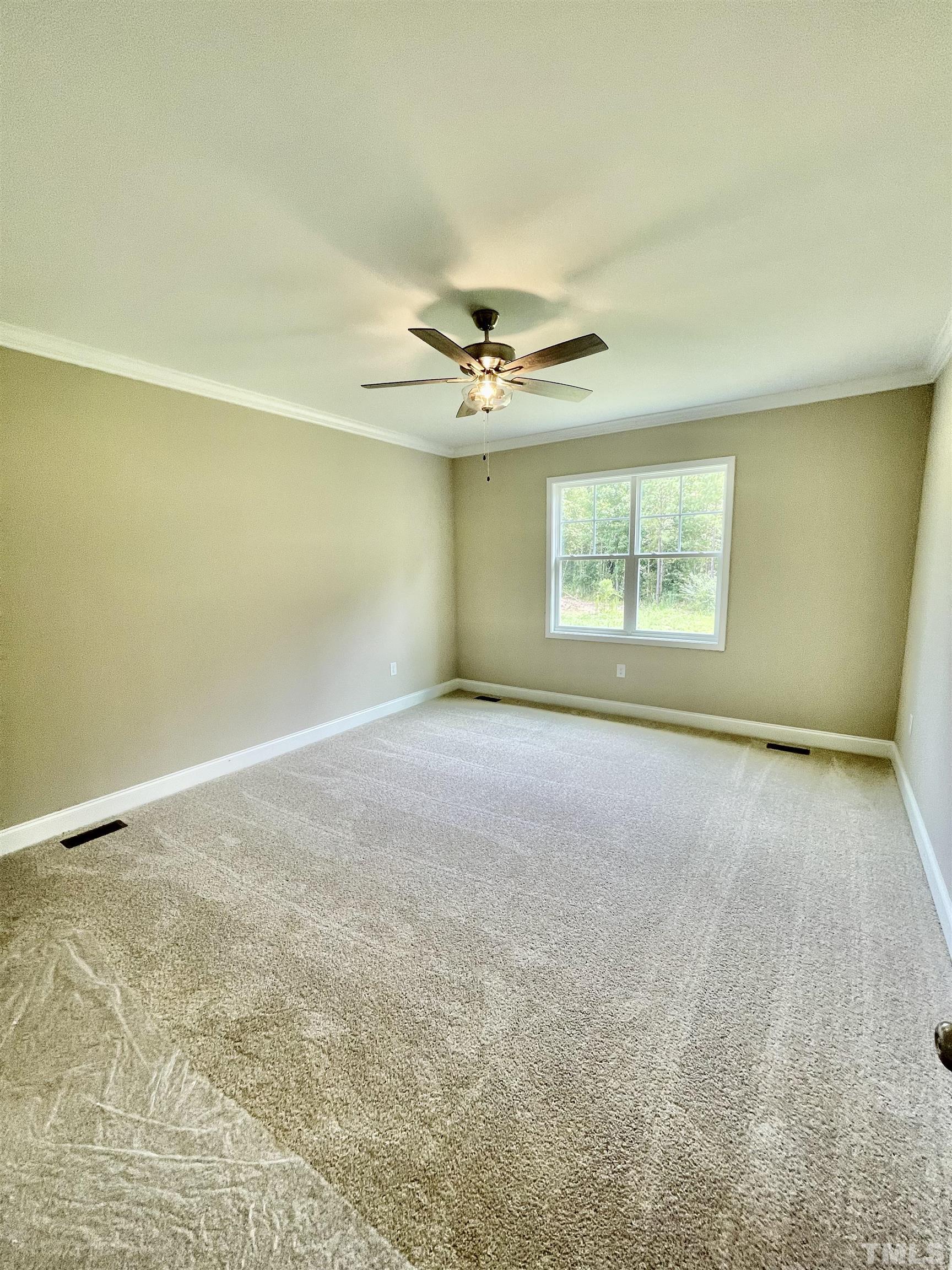 10623 West Old Spring Hope Road Spring Hope, NC 27882 - Photo 22 of 33 an empty room with a ceiling fan and window