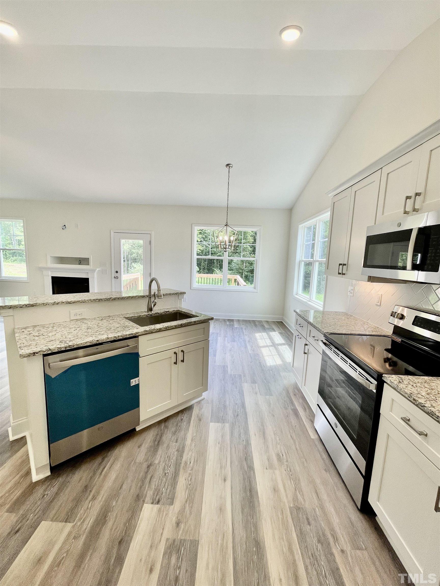 10623 West Old Spring Hope Road Spring Hope, NC 27882 - Photo 8 of 33 a large kitchen with stainless steel appliances granite countertop a stove a sink dishwasher and a oven with white cabinets