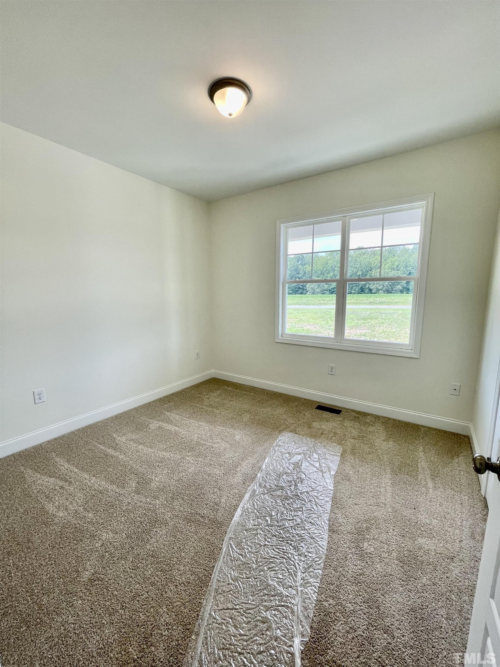 10623 West Old Spring Hope Road Spring Hope, NC 27882 - Photo 9 of 33 an empty room with a fireplace and windows