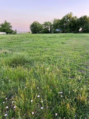 a view of a green field with wooden fence