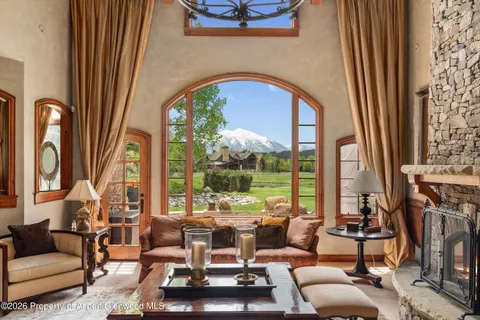 a living room with furniture fireplace and a large window