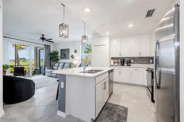 a kitchen with a refrigerator a sink cabinets and wooden floor