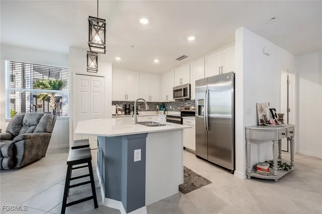 a kitchen with kitchen island a counter top space cabinets and stainless steel appliances