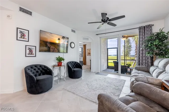 a living room with furniture a flat screen tv and a large window