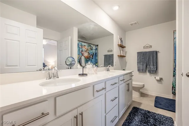 a bathroom with a double vanity sink toilet and shower