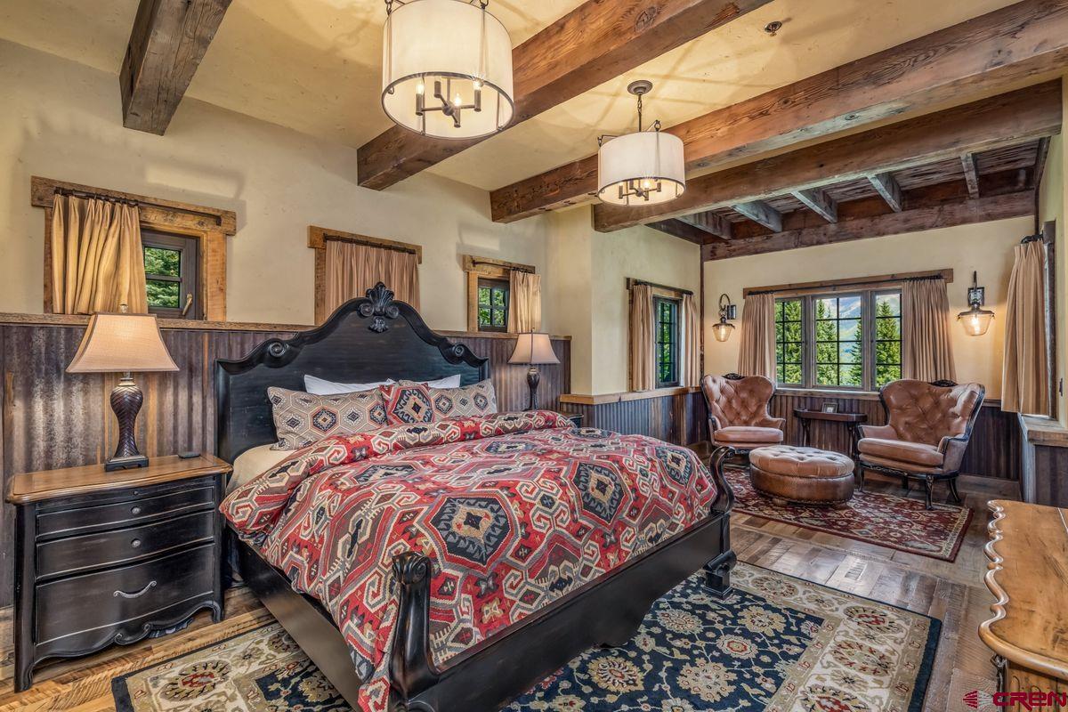 23 Gray Fox Lane Crested Butte, CO 81225 - Photo 27 of 45 a bedroom with a bed a chandelier and dresser