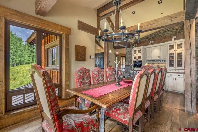a dining room with furniture a chandelier and wooden floor