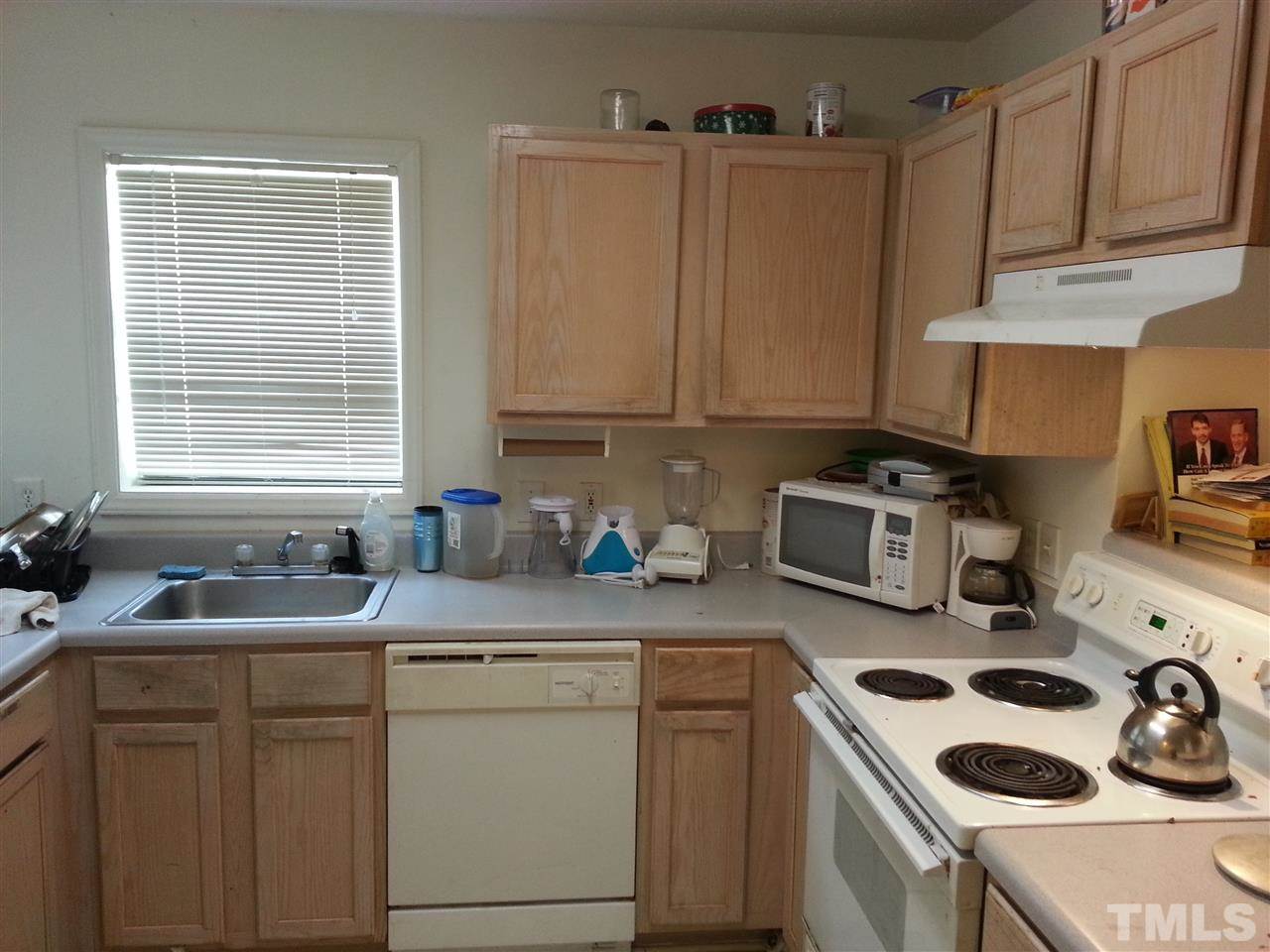 1305 Kent Road, Unit 102 Raleigh, NC 27606 - Photo 3 of 18 a kitchen with sink a stove and cabinets