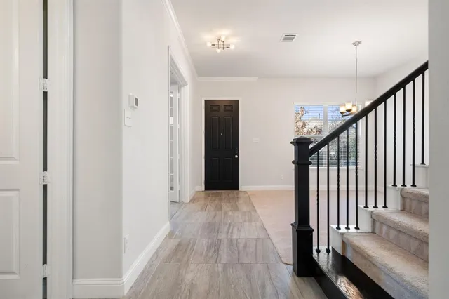 a view of a hallway with wooden floor and staircase