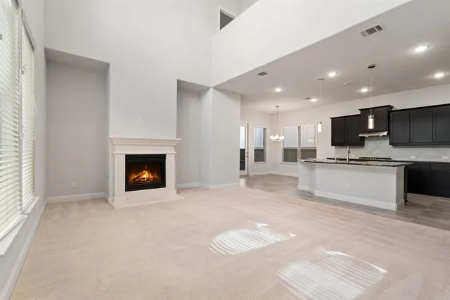 a large white kitchen with kitchen island a sink stainless steel appliances and cabinets