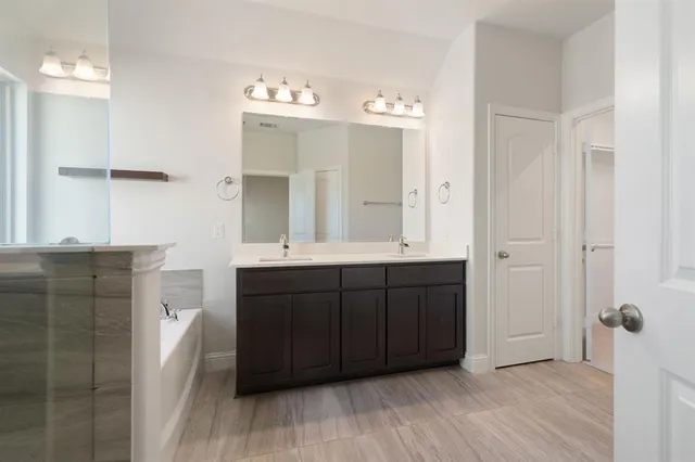 a bathroom with a double vanity sink and mirror