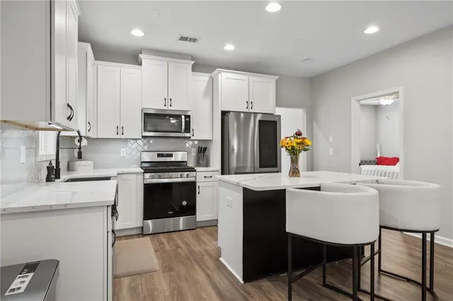 a kitchen with kitchen island a stove a sink and a refrigerator