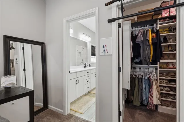 a view of walk in closet with clothes and shoes