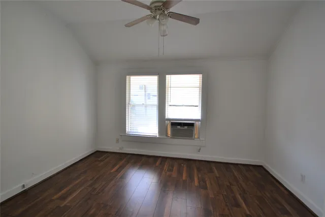 an empty room with a window and wooden floor