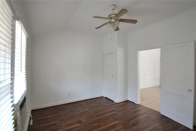 a view of room with hardwood floor and a ceiling fan
