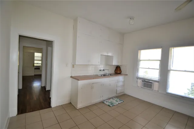 a large kitchen with a refrigerator a sink and dishwasher a oven with white cabinets