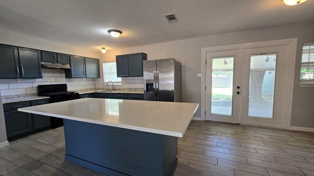 636 Highfall Drive Dallas, TX 75232 - Photo 4 of 14 a large kitchen with stainless steel appliances a large counter top a stove and a refrigerator