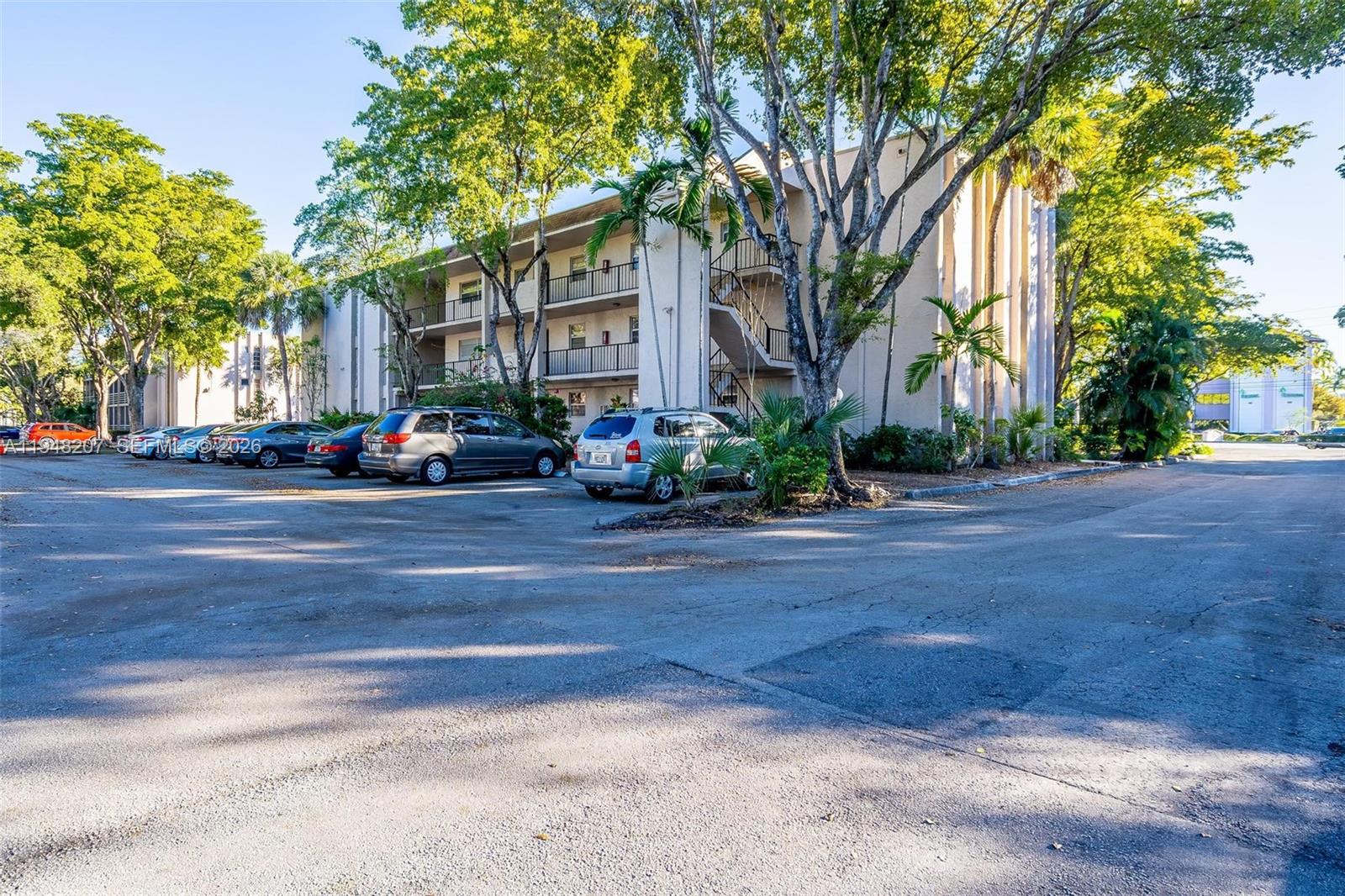 a view of road with house and trees in the background