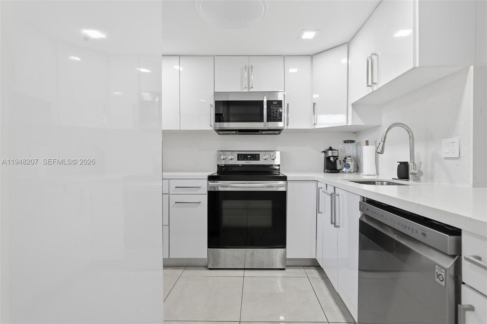 469 North Pine Island Road, Unit B302 Plantation, FL 33324 - Photo 6 of 33 a kitchen with stainless steel appliances granite countertop a stove a sink and a microwave