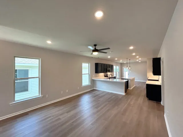 a kitchen view with a sink wooden floor and a living room