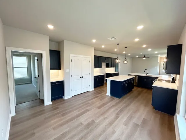 a large kitchen with a large counter top appliances and cabinets